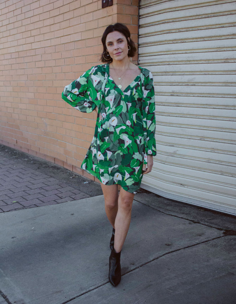 DEVOI Georgia dress in Calla Lilies green print. Knee length with full length sleeves. Front view on model