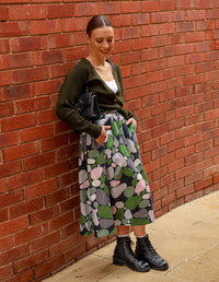 DEVOI Printed Kathleen linen skirt in a green pebbles print. Midi length with pocket and an elasticated waistband. Side front