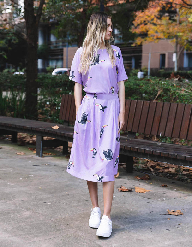 DEVOI Lilac I Can Toucan printed Margot skirt. Midi skirt with a back elasticated waistband and pockets. Front view