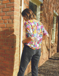 DEVOI Lise top in Rejoice print. round neck, half sleeves. Finishes at the hip. Back view