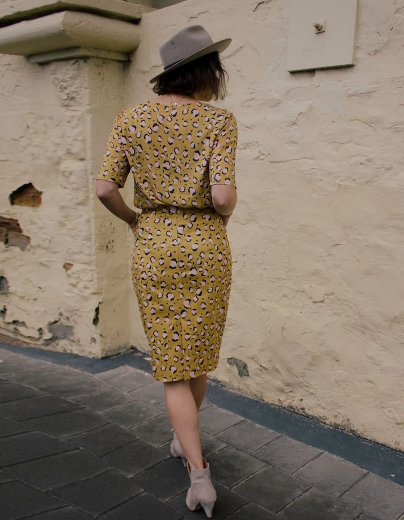 DEVOI Frances skirt in printed Mustard Leopard stretch cotton.  Pencil skirt with pockets, fastened with an invisible zip at the back. Skirt also has a back vent. Back view