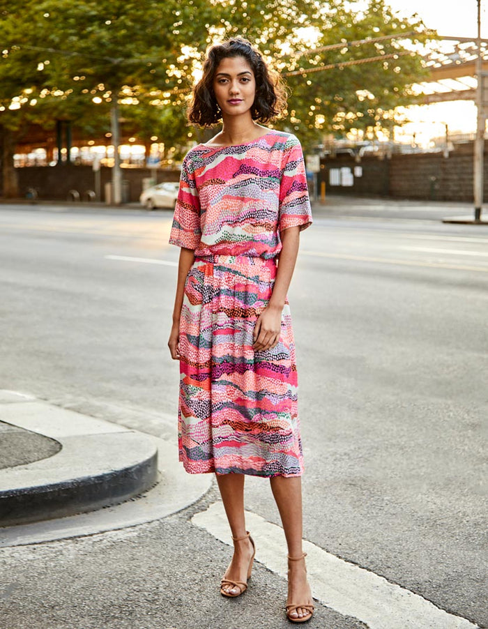 DEVOI pink Margot skirt in Sediment print. Elasticated waistband. Pockets. Midi length. Front view on model.