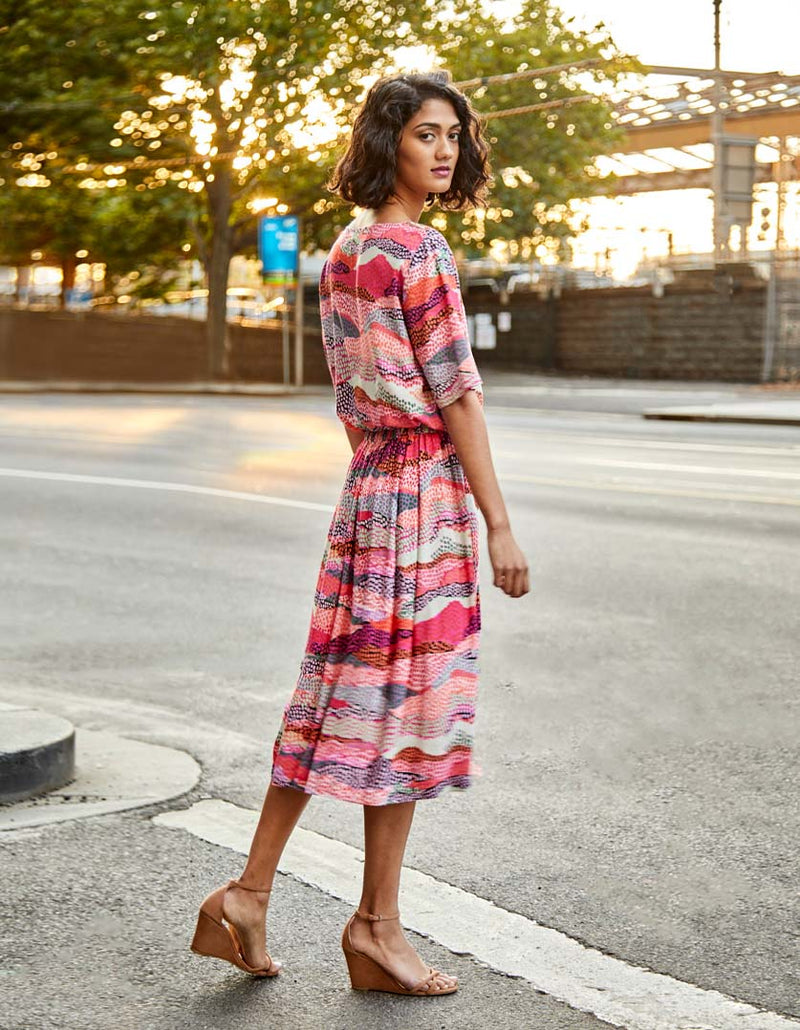 DEVOI pink Margot skirt in Sediment print. Elasticated waistband. Pockets. Midi length. Back view on model.