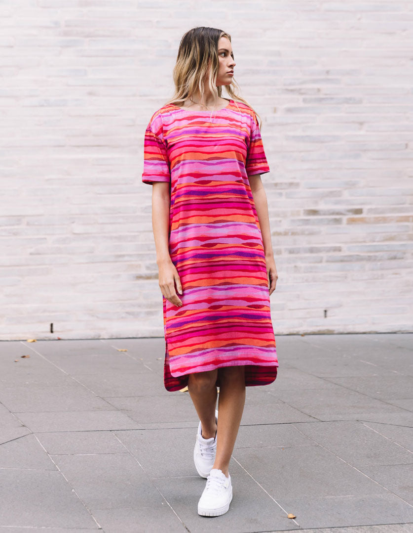 DEVOI Madeleine dress in Sunset tide print. 100% Organic cotton jersey. pink hand painted print. Designed in Melbourne. Short sleeves and side pockets. Front  view