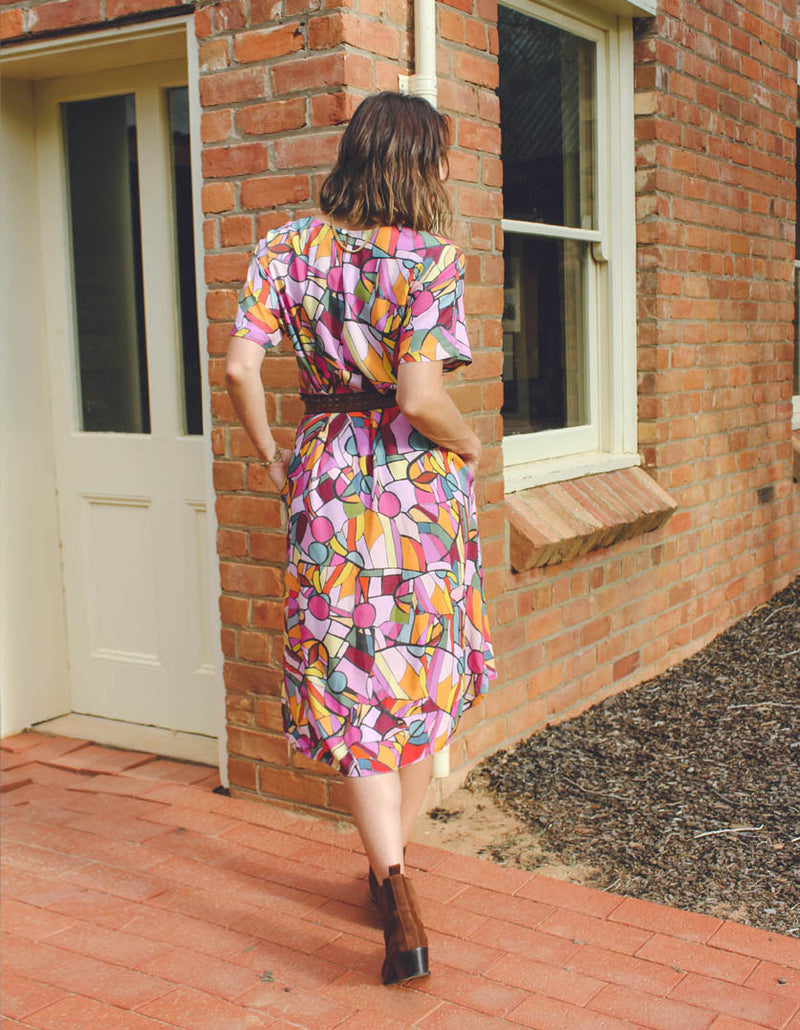 DEVOI Annie dress in Rejoice printed Modal. Belted at the waist and has side pockets! Back view on model.