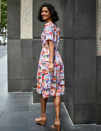 DEVOI White Urban Scapes Dorothy dress in printed Linen. Round neckline. Knee length. Short sleeves. Pockets. Side back view on model.