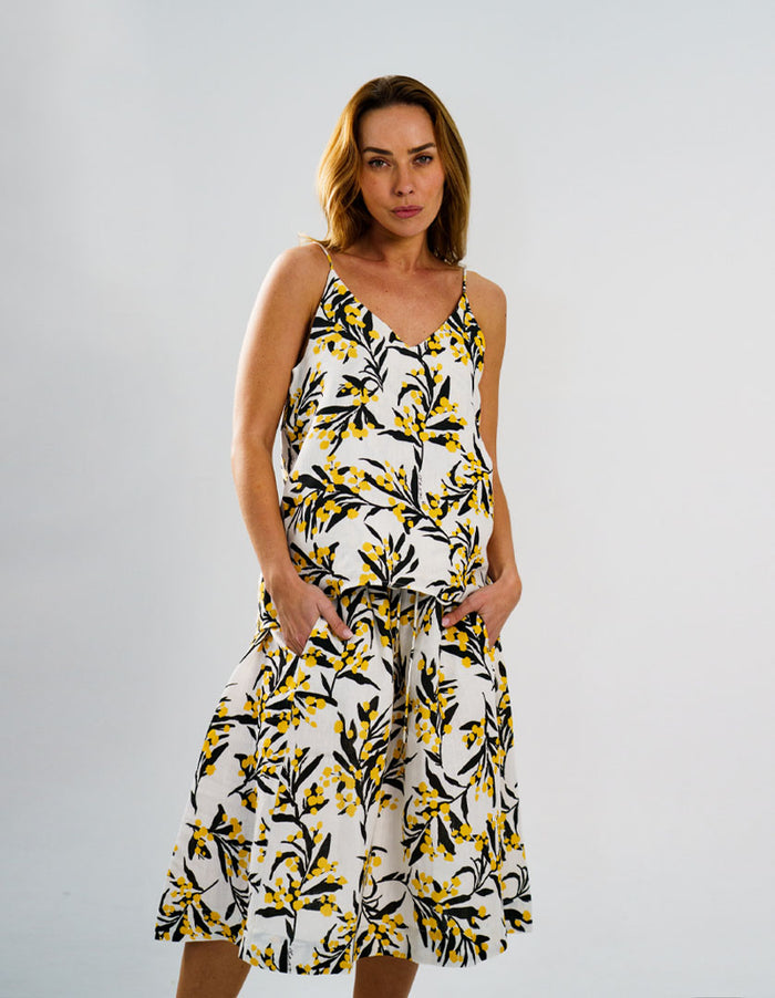 DEVOI Kathleen skirt in golden wattles print. White background with yellow and black. Front view on model