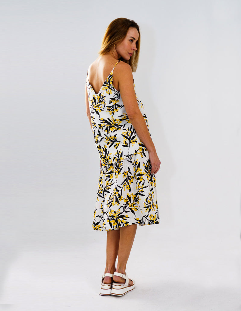 DEVOI Kathleen skirt in golden wattles print. White background with yellow and black. Side back view on model